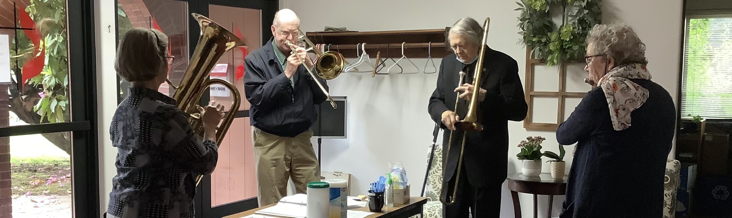 Four horn players warming up in narthex