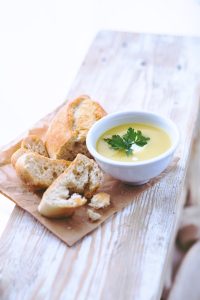picture of a bowl of leek soup and sliced bread on a board